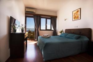 a bedroom with a bed and a television in it at Pigeon Beach Hotel Apartments in Limassol