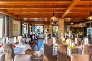 a dining room with white tables and chairs at Kaiser´s Weinland Hotel in Hammelburg