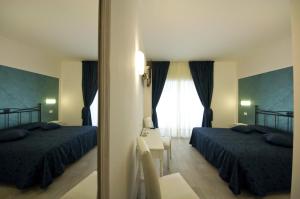 una camera d'albergo con due letti e una finestra di Atlantis Inn Roma a Roma