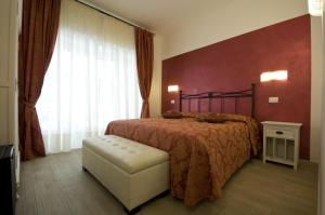 ローマにあるアトランティス イン ローマのベッドルーム1室(ベッド1台、椅子、窓付)