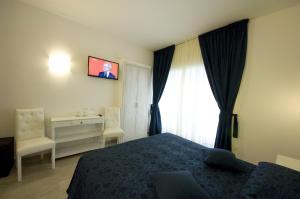 a bedroom with a bed and a desk and a television at Atlantis Inn Roma in Rome