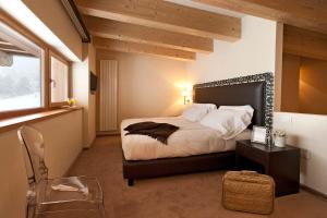 a bedroom with a bed and a table and a window at Grand Hotel Paradiso in Passo del Tonale