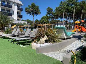 eine Reihe von Liegestühlen und Rutschen in einem Resort in der Unterkunft Hotel Franz in Bibione