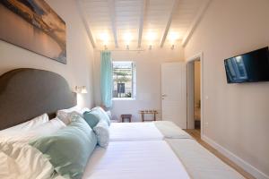 um quarto com uma grande cama branca com almofadas azuis em Melina's Urban Retreat em Corfu Town