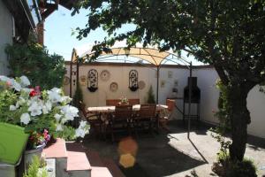 un patio con mesa y sillas bajo una sombrilla en Alojamiento La Olmedana, en Olmedo