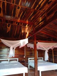 two beds in a room with wooden ceilings at Rice straw Green lodge- resort in Quan Tom