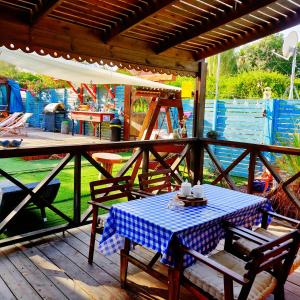 a table with a blue and white checkered table cloth on a porch at Libi Bamidbar, Healing & Relaxation Resort in The Dead Sea in Neʼot HaKikar