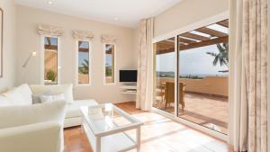 a living room with a couch and a table at Real Agua Amarga La Joya - Adults Only in Agua Amarga