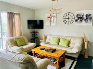 a living room with two couches and a coffee table at A1 Kaikoura Motel & Holiday Park in Kaikoura