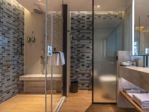 a bathroom with a shower and a sink and a shower at GreenTree Eastern Binhu Road Wanda Hotel in Nanning
