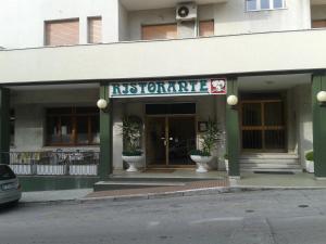 un restaurant avec des plantes en pot devant un bâtiment dans l'établissement Albergo Tenda Verde, à Falconara Marittima