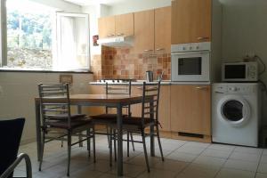 a kitchen with a table and chairs and a washing machine at CURE THERMALE OU VACANCES D'ETE AU MONT DORE in Le Mont-Dore