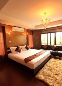 Un dormitorio con una cama grande y una lámpara de araña. en G2 Boutique Hotel, en Chiang Mai