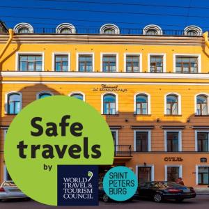 un edificio giallo con un cartello davanti di Cronwell Inn Stremyannaya a San Pietroburgo