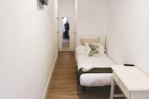 een kleine kamer met een bed en een bureau bij Pensión Estrella in Madrid