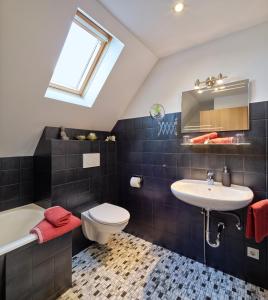 a bathroom with a sink and a toilet and a bath tub at Ferienhaus Götten in Hontheim