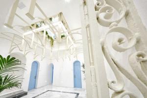 un corridoio con pareti bianche e porte blu di La Casa del Arco a Conil de la Frontera