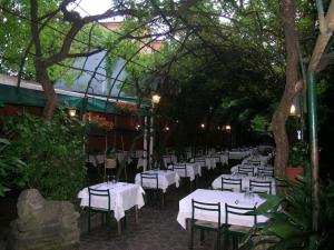 a row of tables with white tablecloths in a garden at Antica Locanda Montin in Venice