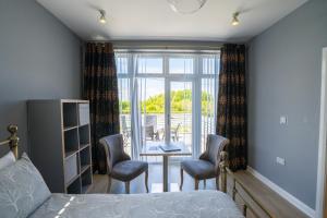 a bedroom with a bed and a table and chairs at Rest a While in Bushmills