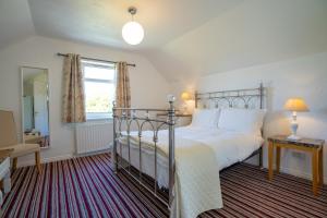 a bedroom with a large bed and a window at Rest a While in Bushmills