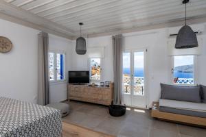 a bedroom with a bed and a couch and windows at Luxury Apartment in the Heart of Astypalaia in Astypalaia Town