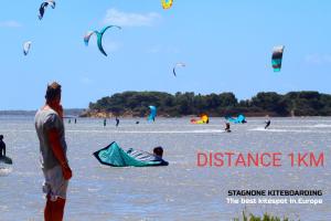 a group of people on a beach flying kites at Tahiti House Stagnone in Marsala