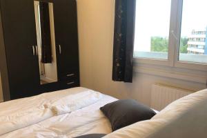 a bedroom with a bed with a mirror and a window at 02 Bedrooms-Paris-Disneyland-WiFi- Parking-RER A in Noisy-le-Grand