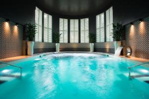 a large swimming pool with blue water in a room at Hedon Spa & Hotel in Pärnu
