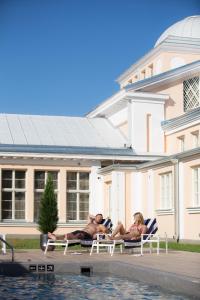 a group of people laying on lawn chairs by a pool at Hedon Spa & Hotel in Pärnu