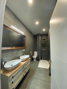 ein Badezimmer mit zwei Waschbecken, einer Dusche und einem WC in der Unterkunft CASA REFORMADA CON TERRAZA/WIFI/AIRE ACONDICIONADO in Sevilla