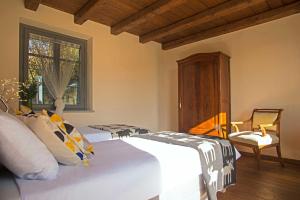 a bedroom with a bed and a chair and a window at Cascina Canée in Angera