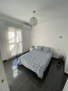 ein Schlafzimmer mit einem Bett in einem weißen Zimmer in der Unterkunft CASA REFORMADA CON TERRAZA/WIFI/AIRE ACONDICIONADO in Sevilla