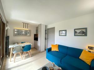 a living room with a blue couch and a table at Hôtel Rent in Megève