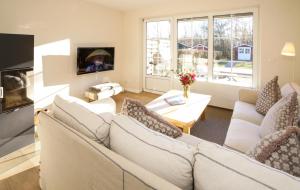 Ferienhaus Frieda Sylt في تينوم: غرفة معيشة مع أرائك بيضاء وتلفزيون