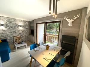 a dining room with a table and blue chairs at Hôtel Rent in Megève