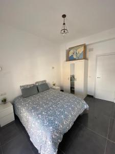 ein Schlafzimmer mit einem großen Bett in einem weißen Zimmer in der Unterkunft CASA REFORMADA CON TERRAZA/WIFI/AIRE ACONDICIONADO in Sevilla
