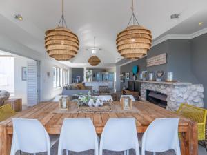 a living room with a large wooden table and chairs at Sandy Toes Beach Villa in Langebaan