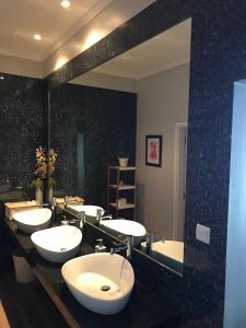 羅安達的住宿－Casas de Luanda GH-Miramar，一间带四个盥洗盆和大镜子的浴室