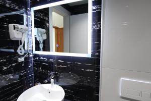a bathroom with a sink and a mirror at Ksamil Central Park Hotel in Ksamil