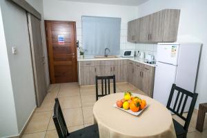 a kitchen with a table with a bowl of fruit on it at Crystallo Apartments in Paphos