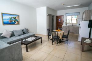 a living room with a couch and a table and a kitchen at Crystallo Apartments in Paphos