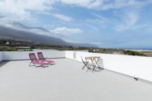 夫隆特拉的住宿－Apartamentos Los Arroyos，屋顶上配有两把粉红色的椅子和一张桌子