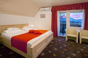 a bedroom with a large bed and a window at Alp Pension in Bled