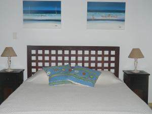 a bedroom with a bed with two lamps and two pictures at Pé na Areia in Conde