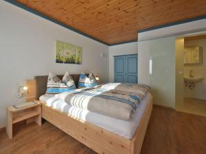 a bedroom with a large bed with a wooden ceiling at Haus Hasslacher in Flattach