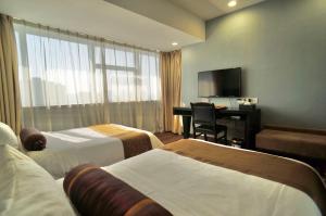 廣州的住宿－廣州天一酒店，酒店客房设有两张床、一张桌子和一台电视。