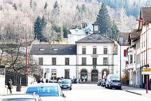 une rue de la ville avec des voitures garées devant un bâtiment dans l'établissement Le 1A, Charmant Appartement au Cœur de la Ville, à Gérardmer