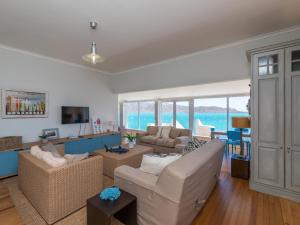 a living room with a couch and a table at Lagoon Escape Beach Villa in Langebaan