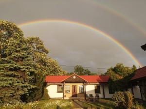 a rainbow in the sky above a house at Agroturystyka Wilczyn Cegielnia in Wilczyn