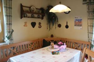 a table with a white table cloth and flowers on it at Ferienwohnung Sattler in Neukirchen am Teisenberg